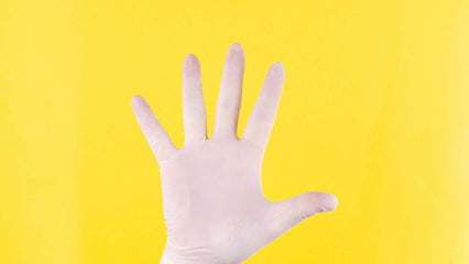 Hand in white glove against yellow background