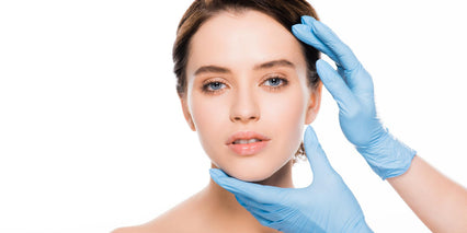 hands with gloves touching a woman's face
