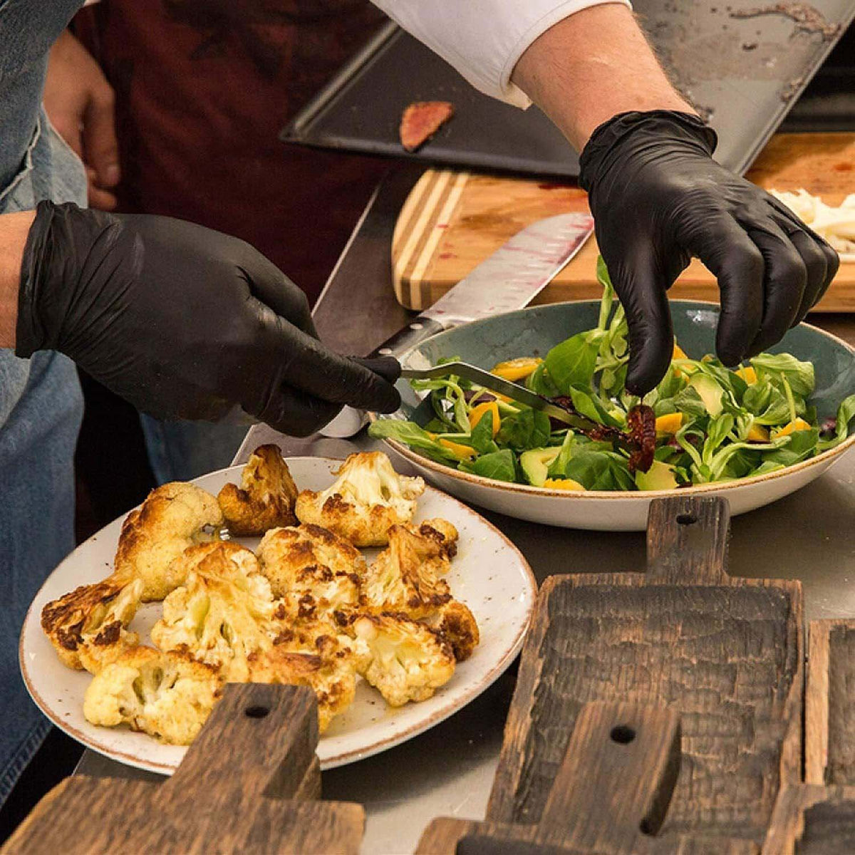 a chef preparing a food while wearing black gloves