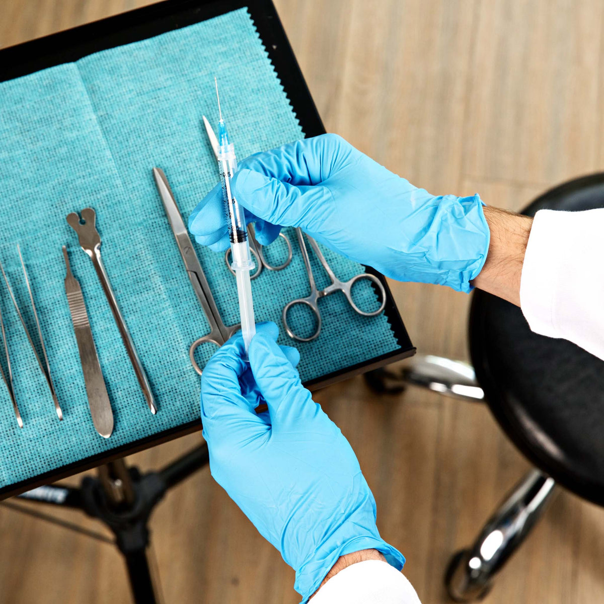 a medical professional in HandCare Blue Nitrile Gloves preparing examination tray