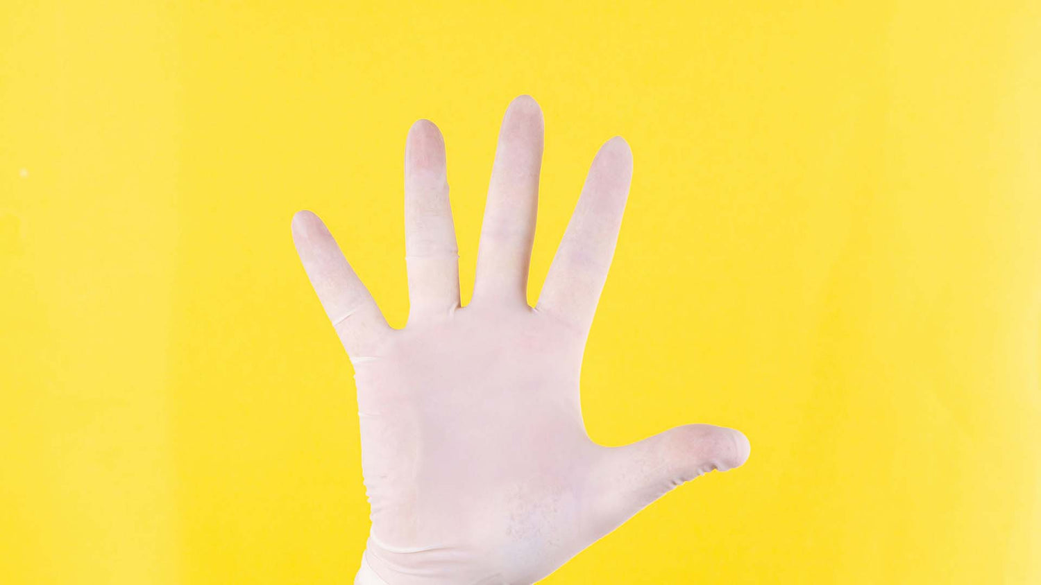 Hand in white glove against yellow background