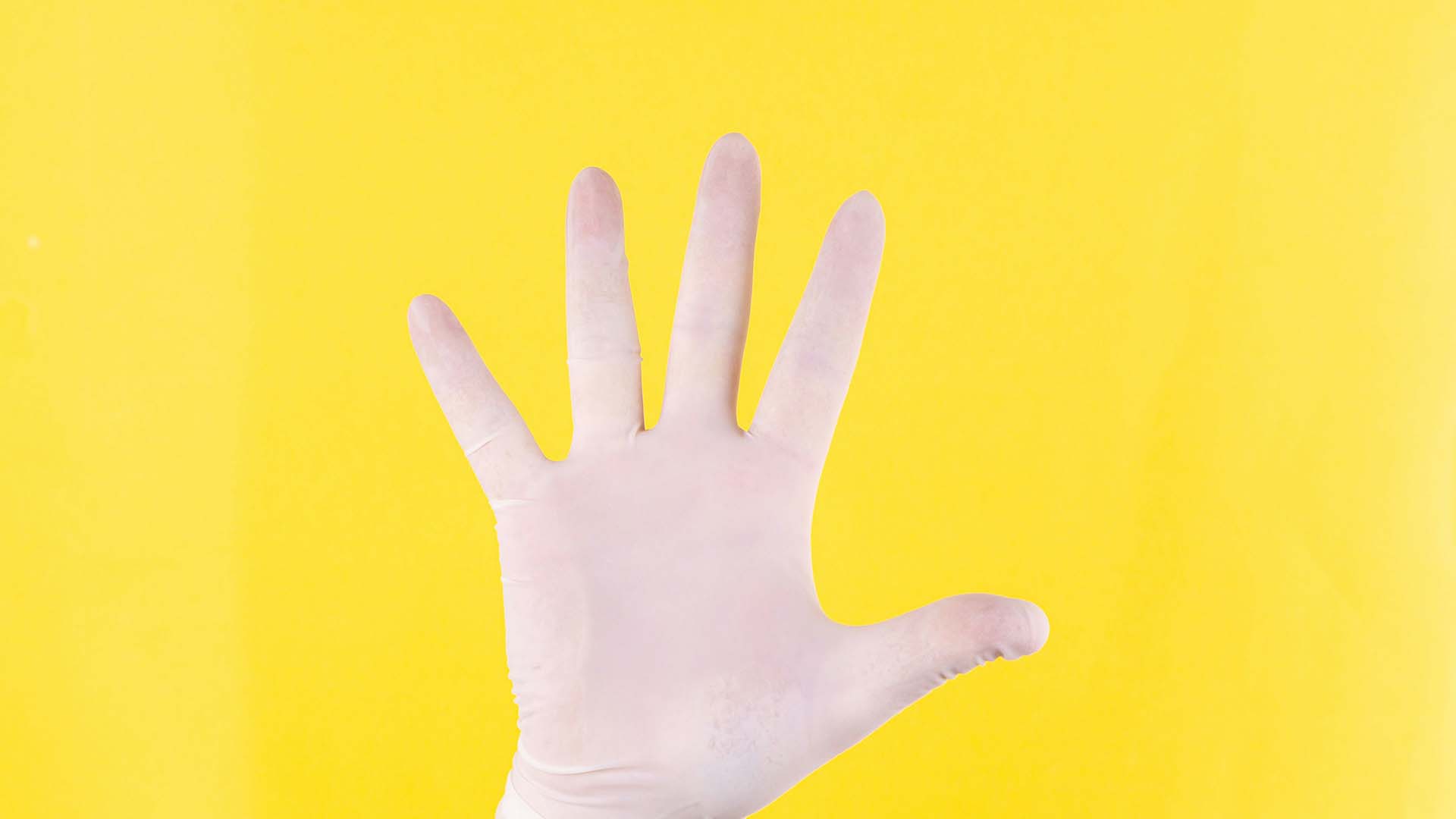 Hand in white glove against yellow background