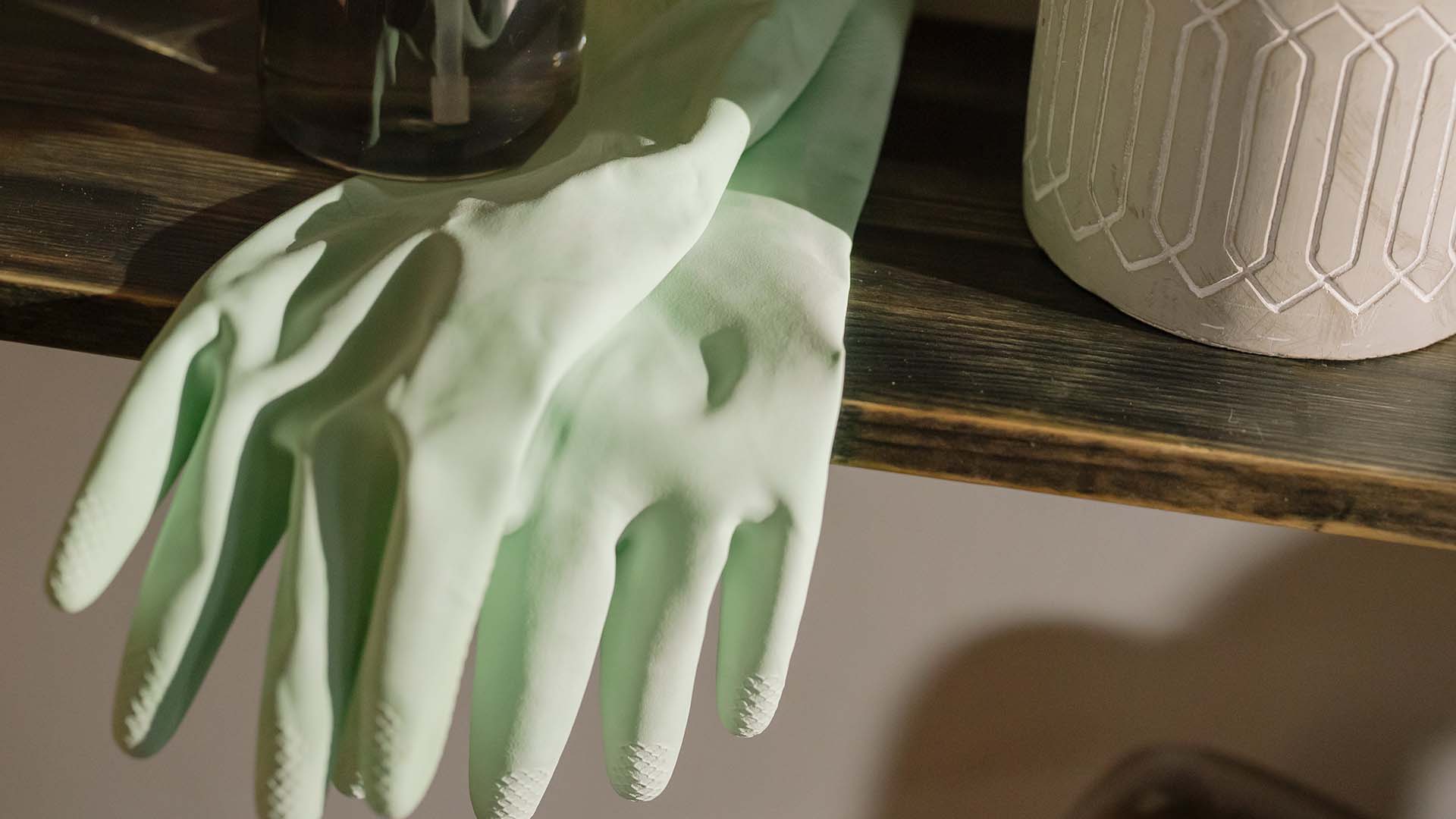 latex gloves in between a black bottle and white plant pot