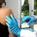 a doctor wearing HandCare Blue Nitrile Gloves while giving an intramuscular (IM) injection to a patient